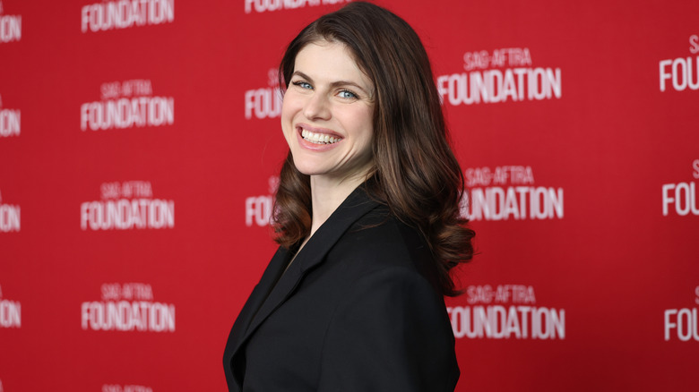 Alexandra Daddario smiling while posing on the red carpet in May 2026