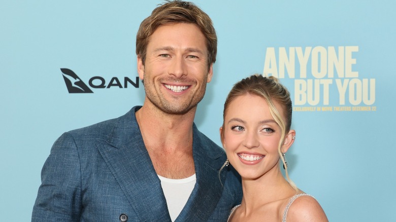 Glen Powell and Sydney Sweeney smiling together on red carpet