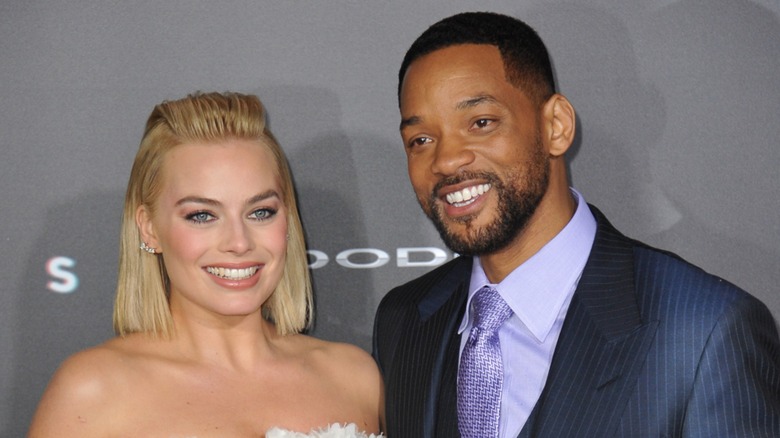 Margot Robbie and Will Smith smiling together on red carpet