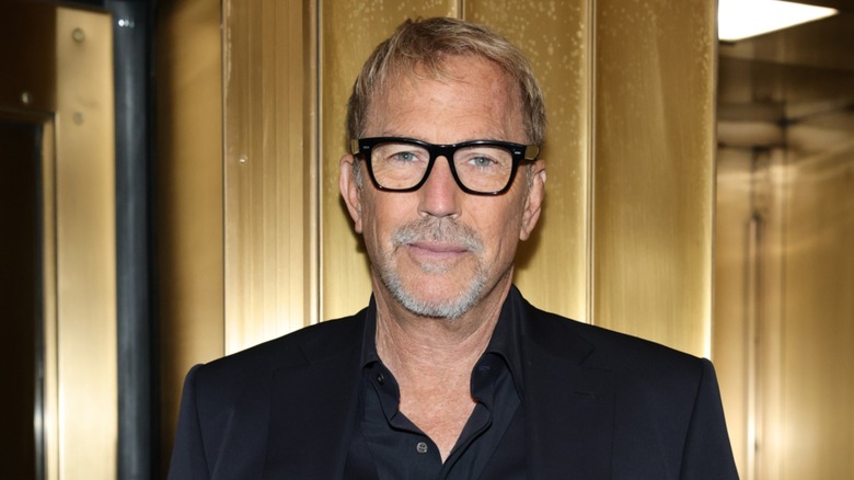 Kevin Costner posing in a black suit