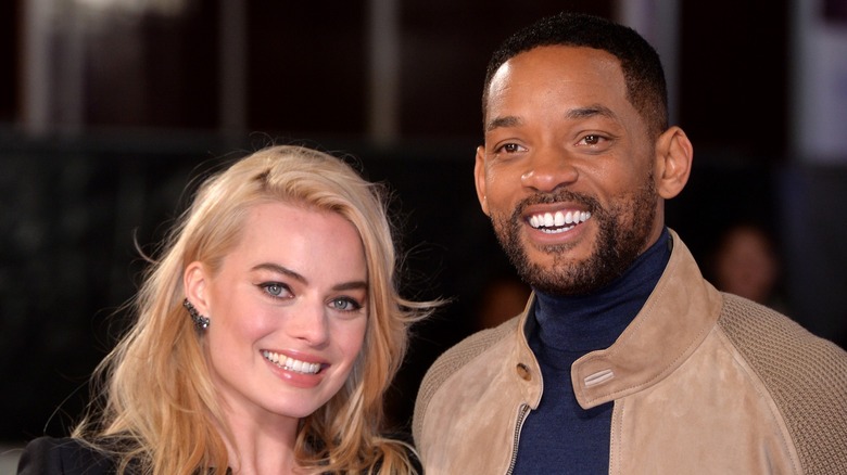 Margot Robbie and Will Smith smiling together at an event
