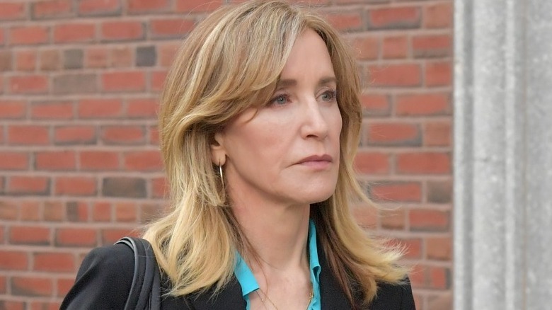 Felicity Huffman walking by brick wall