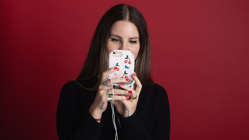 Lana Del Rey looking at her iPhone