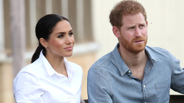 Meghan Markle and Prince Harry looking off to the side