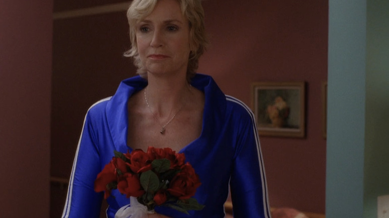 Sue Sylvester holding flowers while preparing to marry herself in episode of "Glee"
