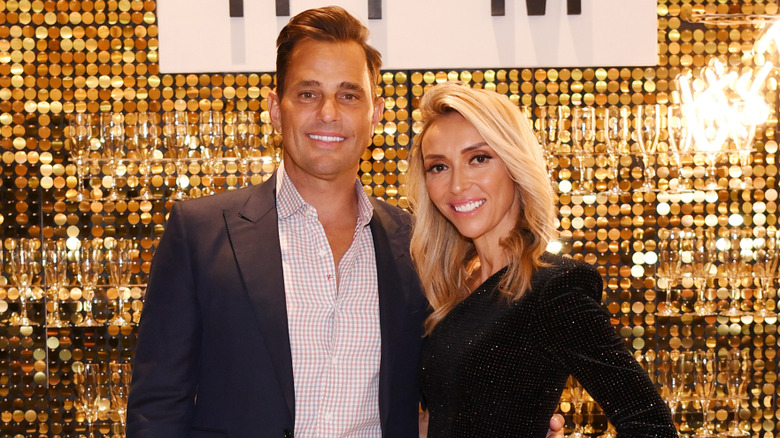 Bill and Giuliana Rancic smiling while posing on a 2022 red carpet together