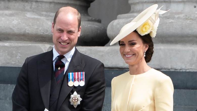 Prince William smiling and Kate Middleton wearing yellow hat
