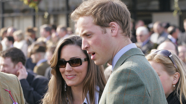 Young Kate Middleton wearing sunglasses and young Prince William speaking
