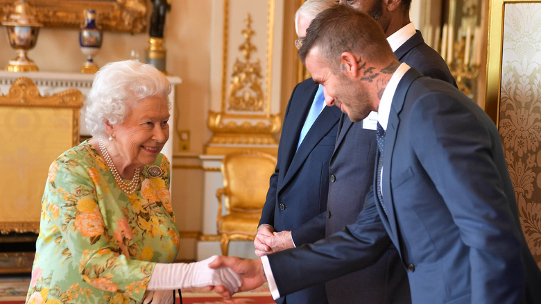 David Beckham taking Queen Elizabeth II's hand