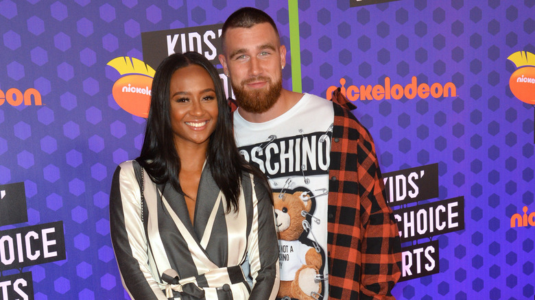 Travis Kelce standing behind Kayla Nicole