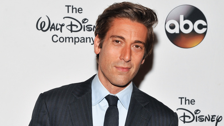 David Muir poses before ABC and Disney logos