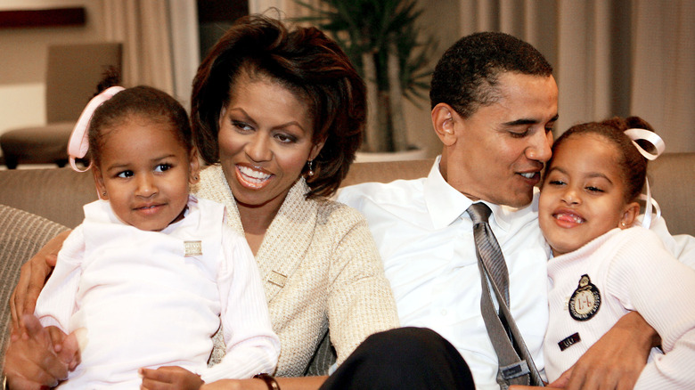 Malia and Sasha Obama in parents' laps