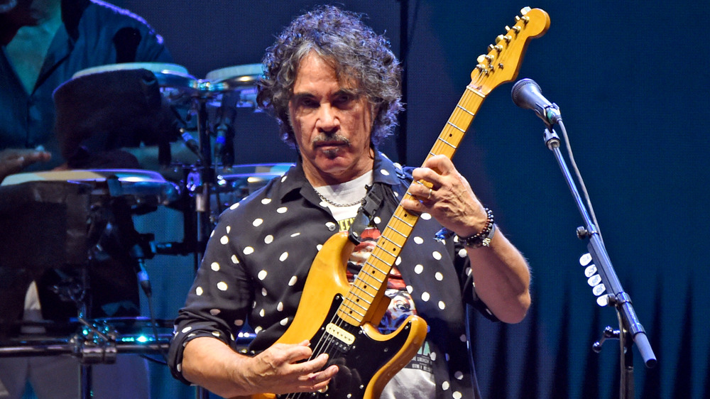 John Oates playing guitar on stage