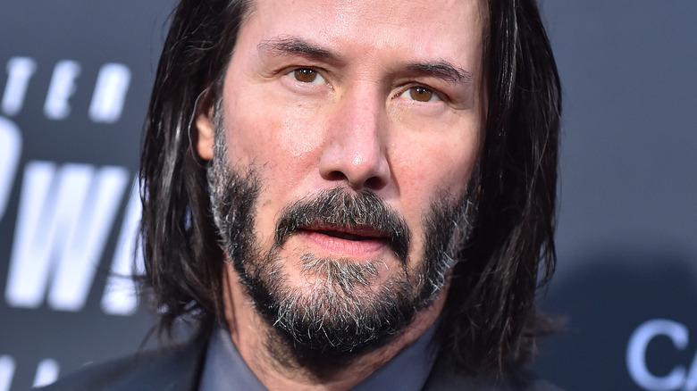 Keanu Reeves sports beard and long hair