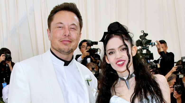Elon Musk posing with Grimes on the Met Gala red carpet