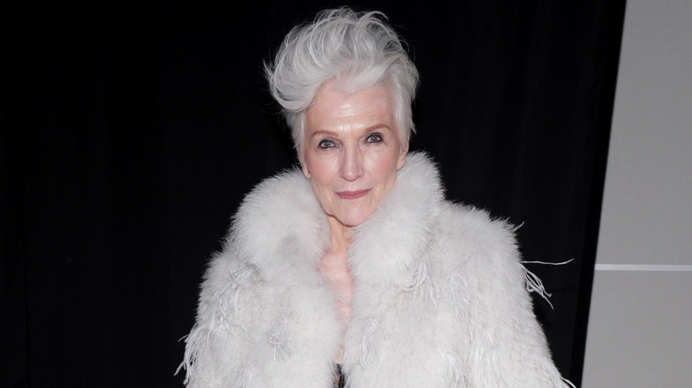Maye Musk posing and wearing a fur coat at an event