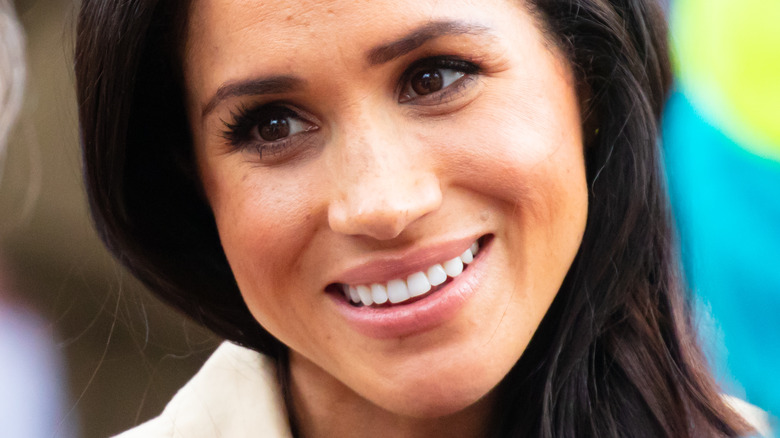 Meghan Markle smiling over her shoulder