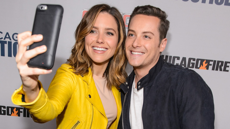 Jesse Lee Soffer and Sophia Bush taking a selfie together on the red carpet.