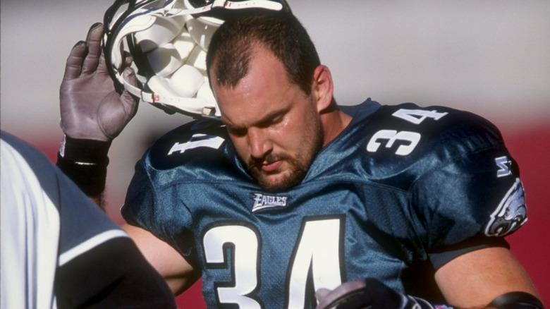 Kevin Turner removing football helmet