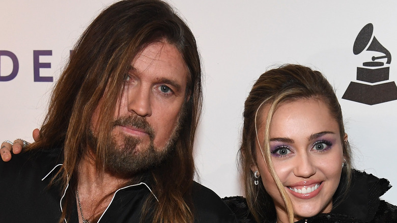 Billy Ray and Miley Cyrus stand side-by-side in close-up