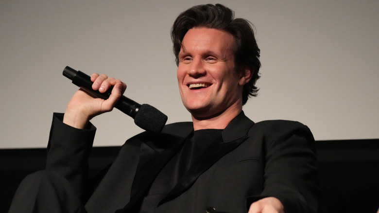 Matt Smith smiling holding a microphone during a Q&A event
