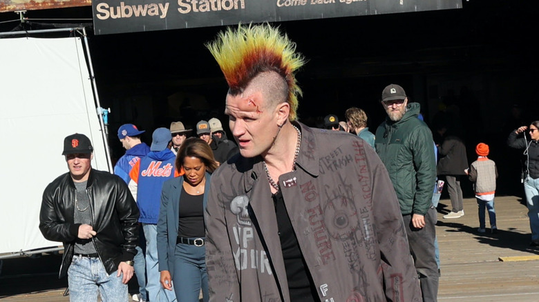 Matt Smith sporting a red and yellow mohawk and battered trenchcoat while filming Caught Stealing