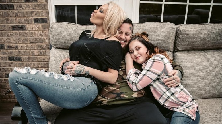 Bunnie Xo and Bailee Ann sitting atop Jelly Roll on a couch in 2020