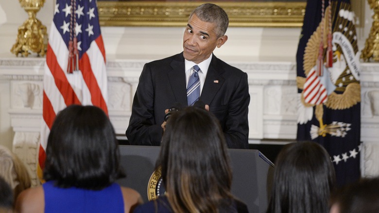 Barack Obama eyeing his daughters at an event