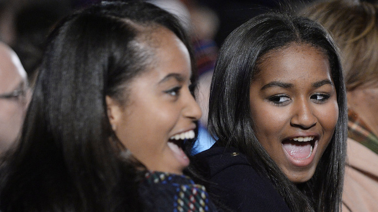 Malia and Sasha Obama smiling at an event