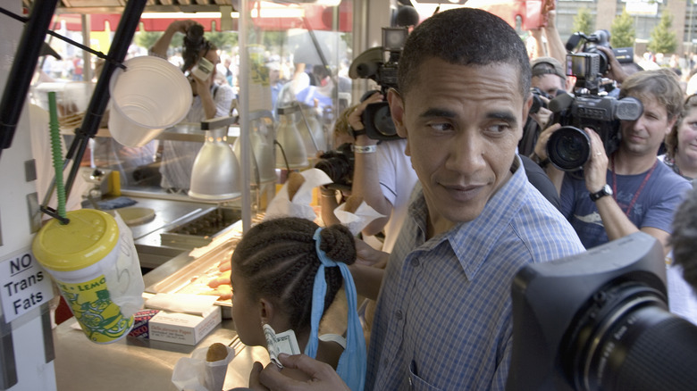 Barack Obama paying for food in front of photographers