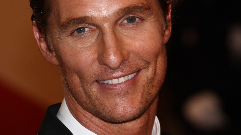 Matthew McConaughey smiling in a suit.