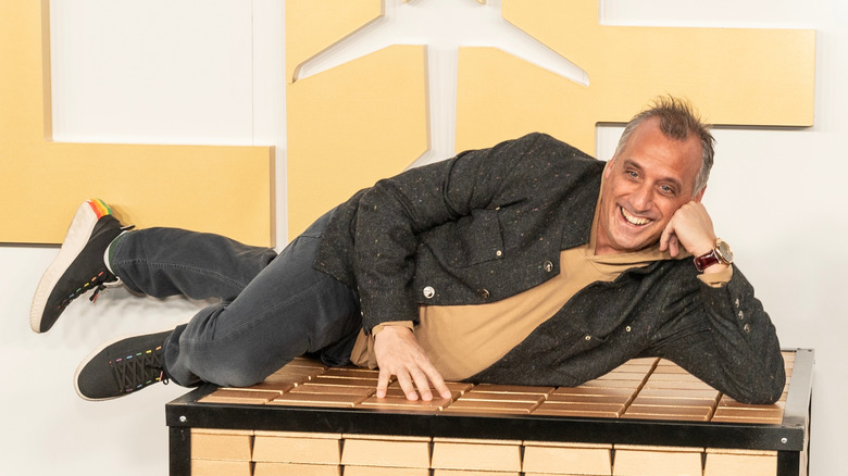 Joe Gatto at premiere of Lift, posing horizontally atop a large table