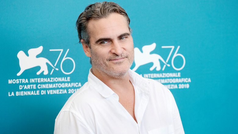 Joaquin Phoenix smirking to side