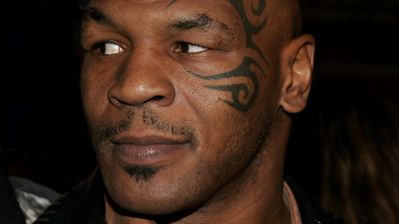 Mike Tyson with face tattoo looking off to the side