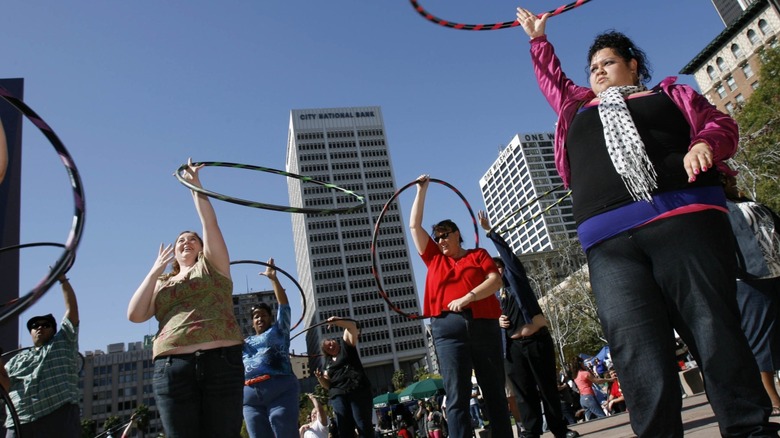 Potential contestants spin hula hoops during a cardio routine