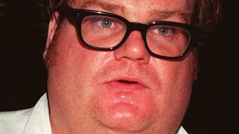 Chris Farley wears black rimmed glasses