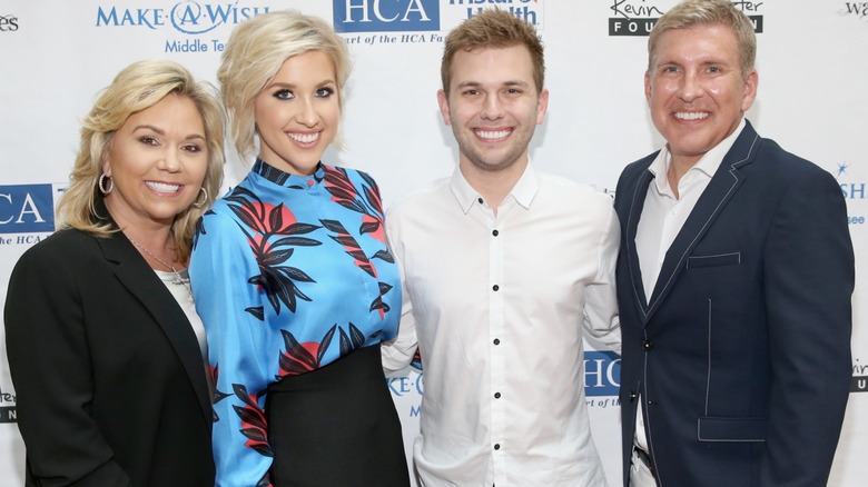 The Chrisley family poses close to each other while sporting gleeful smiles.