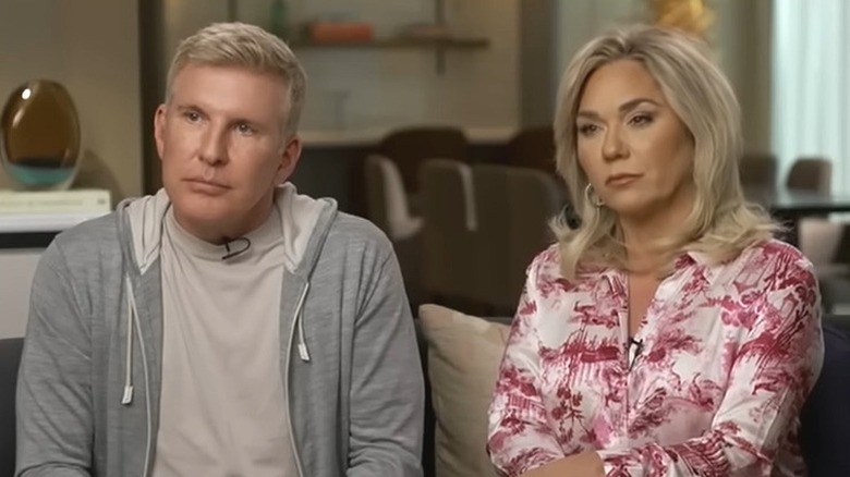 Todd and Julie Chrisley look away from the camera while wearing sad faces.