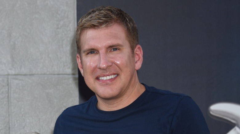 Dressed in a navy blue shirt, Todd Chrisley pastes a wide smile.