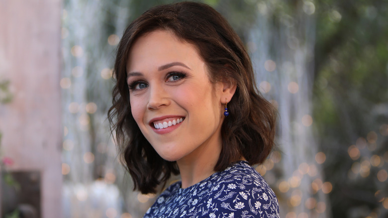 Erin Krakow smiling while looking over her shoulder at 