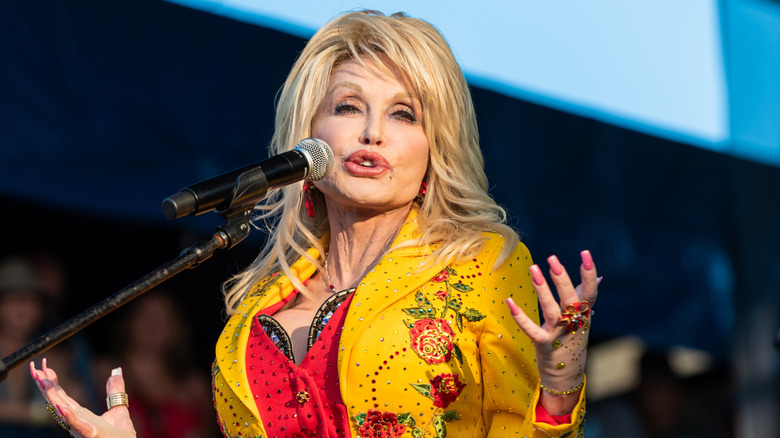 Dolly Parton performing onstage in a sparkly yellow jacket 2019