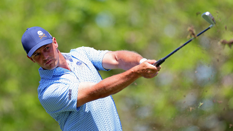 Bryson DeChambeau strikes ball in light blue shirt
