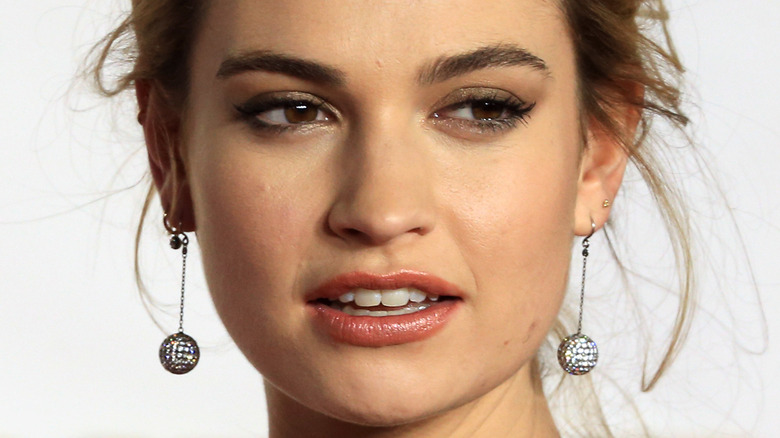 Lily James slightly squinting and looking to the side