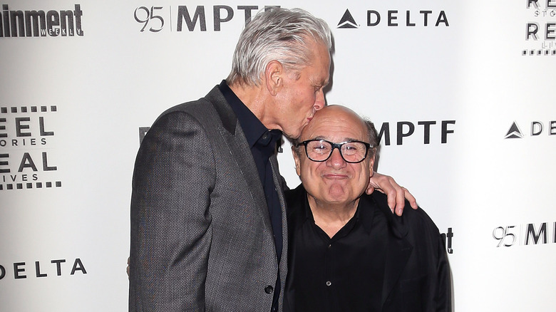 Michael Douglas kissing Danny DeVito on the head