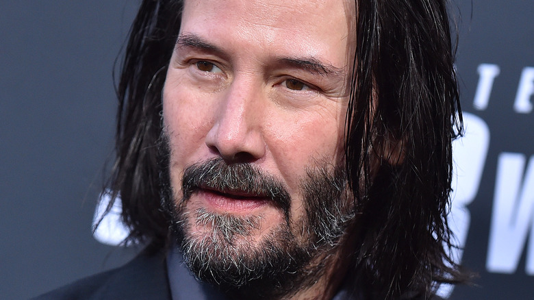 Keanu Reeves looking to the side with relaxed expression