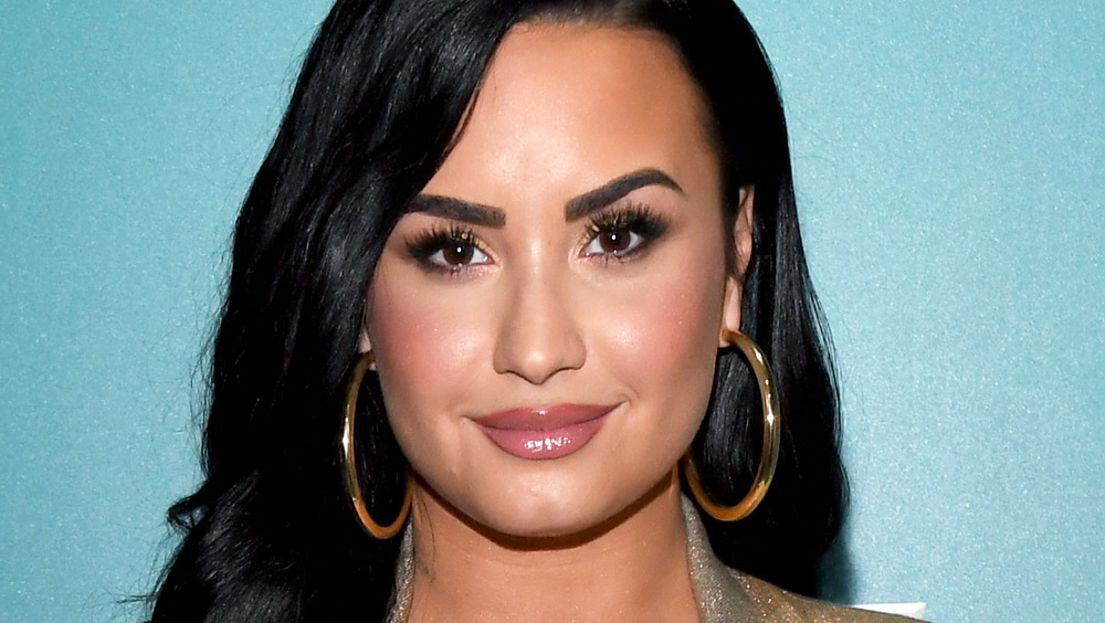 Demi Lovato poses with large hoop earrings.