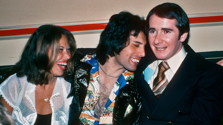 Freddie Mercury at a party, seated and laughing