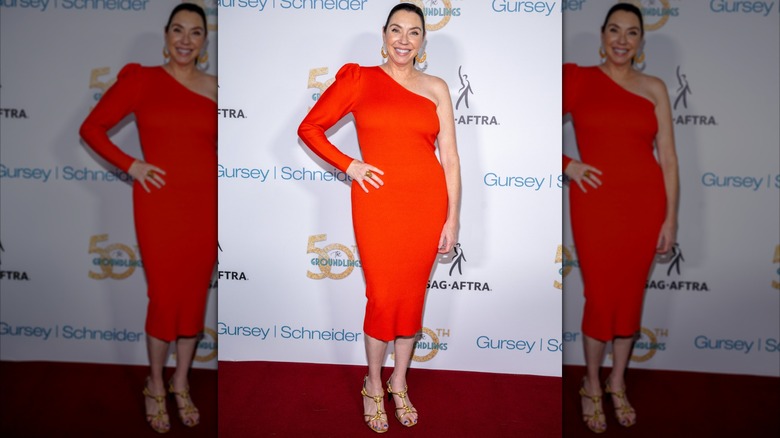 Stephanie Courtney posing in a tangerine dress.