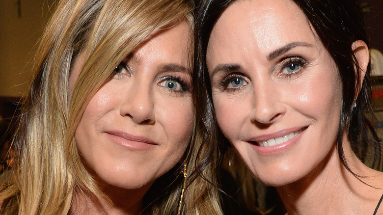 Jennifer Aniston and Courteney Cox posing at an event