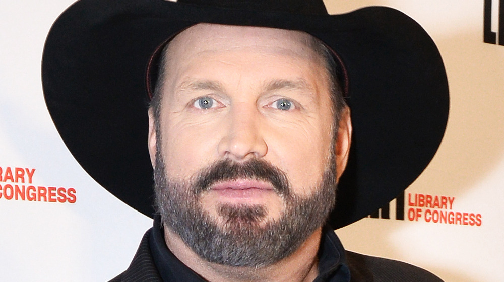 Garth Brooks poses in a black cowboy hat